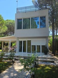 a large white house with large windows at Vila Eva Lalz in Draç
