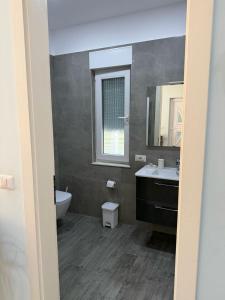 a bathroom with a sink and a toilet and a window at Vila Eva Lalz in Draç +18 photos