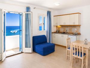 a kitchen and dining room with a blue chair and a table at Dream Island Hotel in Livadia +7 photos