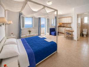 a bedroom with a blue bed and a kitchen at Dream Island Hotel in Livadia