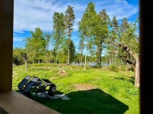 a picnic table and bench in a field with trees at Holiday home Småland Siggamåla in Husjönäs