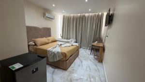 a small living room with a couch and a television at Pyramids gardens guest House in ‘Ezbet `Abd el-Ḥamîd