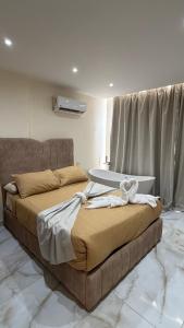 a bedroom with a large bed with a bath tub at Pyramids gardens guest House in ‘Ezbet `Abd el-Ḥamîd