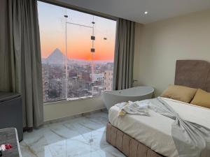 a bedroom with a bed and a view of the pyramid at Pyramids gardens guest House in ‘Ezbet `Abd el-Ḥamîd +27 photos
