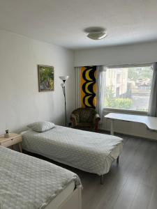 a hotel room with two beds and a window at Large apartment in the centre of Jyväskylä with private swimming pool and sauna in Jyväskylä