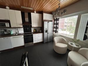 a kitchen with white cabinets and a stainless steel refrigerator at Large apartment in the centre of Jyväskylä with private swimming pool and sauna in Jyväskylä