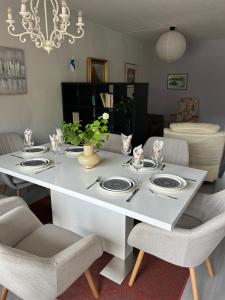 a white dining room table with plates and chairs at Large apartment in the centre of Jyväskylä with private swimming pool and sauna in Jyväskylä