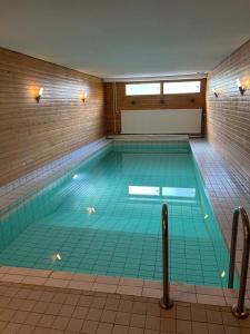 a large swimming pool with an empty at Large apartment in the centre of Jyväskylä with private swimming pool and sauna in Jyväskylä
