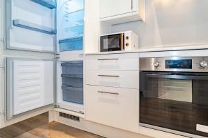 a kitchen with white cabinets and a microwave at Gabriel's Gaff in Maidstone +30 photos