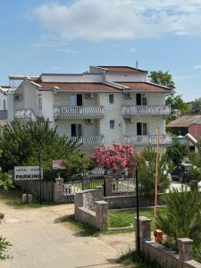 a large white building with a sign in front of it at Belmare in Ulcinj