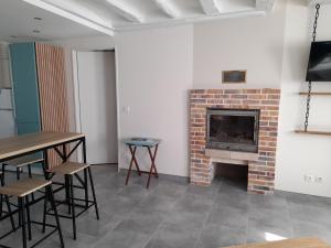 a living room with a fireplace and a table and chairs at Le lit de la SEINE in Saint-Seine-lʼAbbaye