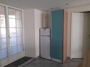 a kitchen with a refrigerator next to a window at Le lit de la SEINE in Saint-Seine-lʼAbbaye