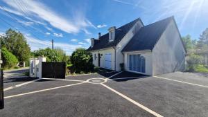 a white house with a parking lot at La Parenthèse by CHERDECOUVERTE in Sambin