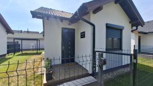 a house with a black door and a fence at Argent apartman in Balatonmáriafürdő
