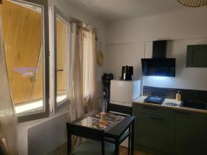 a small kitchen with a small table and a counter at Elegant studio Hyper center in Rodez