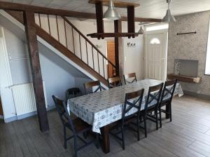 a dining room with a table and chairs and a staircase at Gite Auvraysien 10p in La Forêt-Auvray