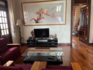 a living room with a tv and a coffee table at Hostel Phuong Nga in Da Lat