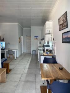 a kitchen with a counter and a table in a room at OysterCatcher Self-Catering Accommodation Strand in Cape Town