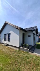 a white house with some plants in a yard at Argent apartman in Balatonmáriafürdő
