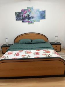 a bedroom with a wooden bed with flowers on it at Orchidea Apartman in Bačka Topola