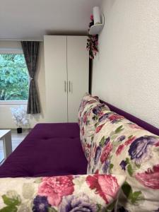 a bedroom with a bed with a floral pillow and a window at Georgeous lux apartment # purple in Foča