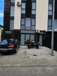 a motorcycle parked in a parking lot in front of a building at Ninche's Penthouse - free private parking in Pljevlja