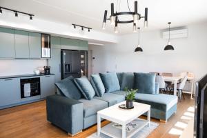 a living room with a blue couch and a kitchen at MarienHome Loojangu in Haapsalu +45 photos