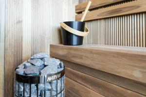 a trash can with a bucket of rocks on a wall at MarienHome Loojangu in Haapsalu