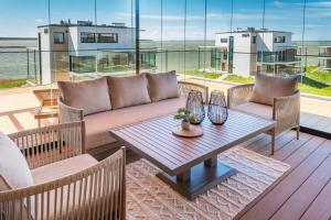 a patio with a couch and a table on a deck at MarienHome Loojangu in Haapsalu