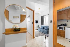 a kitchen and a living room with a mirror at Julies Studios in Chania