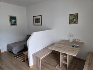 ein kleines Zimmer mit einem Tisch und einem Bett in der Unterkunft Garni Schuster in Corzes + 6 Fotos