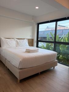 a bedroom with a large bed and a large window at 2 Bed & 2 Bath Suite, 2nd floor in Ban Bang Toei (1)