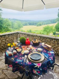 a table with a table cloth with food on it at Chambre d'hôtes l'Heure Bleue in Saint-Alvère