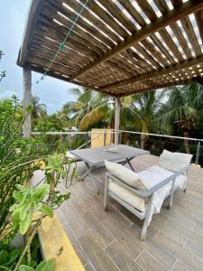 a wooden deck with a table and a wooden pergola at Casa Tio 1,quiet ground floor apartment in El Cuyo