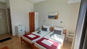 a bedroom with a bed with a red blanket at Pension Mando in Skiathos +19 photos