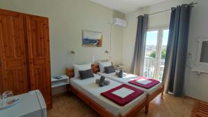 a bedroom with two beds and a window at Pension Mando in Skiathos