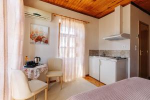 a room with a bed and a table and a kitchen at Clio apartments in Kambos