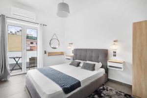 a bedroom with a large bed and a balcony at Julies Studios in Chania