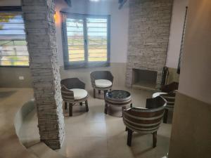 a living room with chairs and tables and a brick wall at Cabaña con parque en Tupungato in Tupungato
