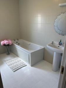 a white bathroom with a tub and a sink at Seaview in Enniscrone