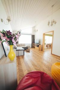 a living room with a yellow vase with flowers on a table at MADARAS Country house in Ventava