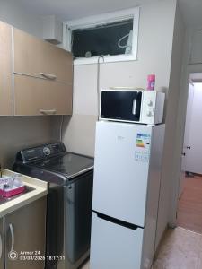 a small kitchen with a microwave on top of a refrigerator at Tsogoo Guesthouse Shared rooms in Ulaanbaatar