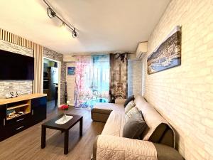 a living room with a couch and a tv at studio city center beach side free paddle beautiful terrace in Nice