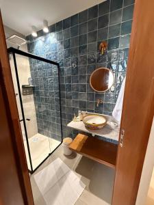 a bathroom with a sink and a glass shower at Apartamento Guarapari temporada in Guarapari