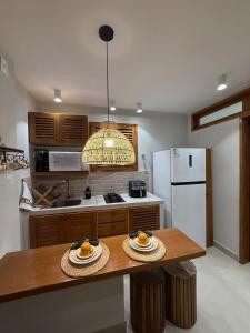 a kitchen with a table and a white refrigerator at Apartamento Guarapari temporada in Guarapari +10 photos