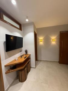 a room with a desk and a tv on the wall at Apartamento Guarapari temporada in Guarapari