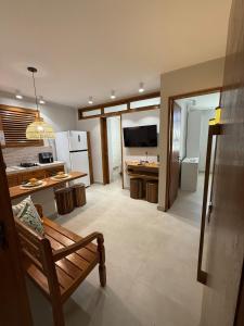 a kitchen with a bench and a table in a room at Apartamento Guarapari temporada in Guarapari
