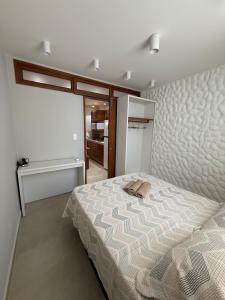 a bedroom with a bed with a purse on it at Apartamento Guarapari temporada in Guarapari