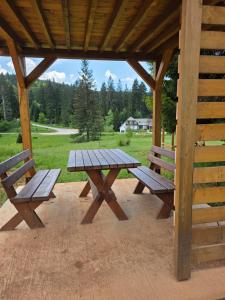 a picnic table in a pavilion with two benches at Apartmani Suncani breg Tara in Mitrovac