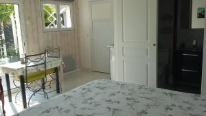 a bedroom with a bed and a table and a window at Chambre d'hôtes du Carrousel in La Teste-de-Buch